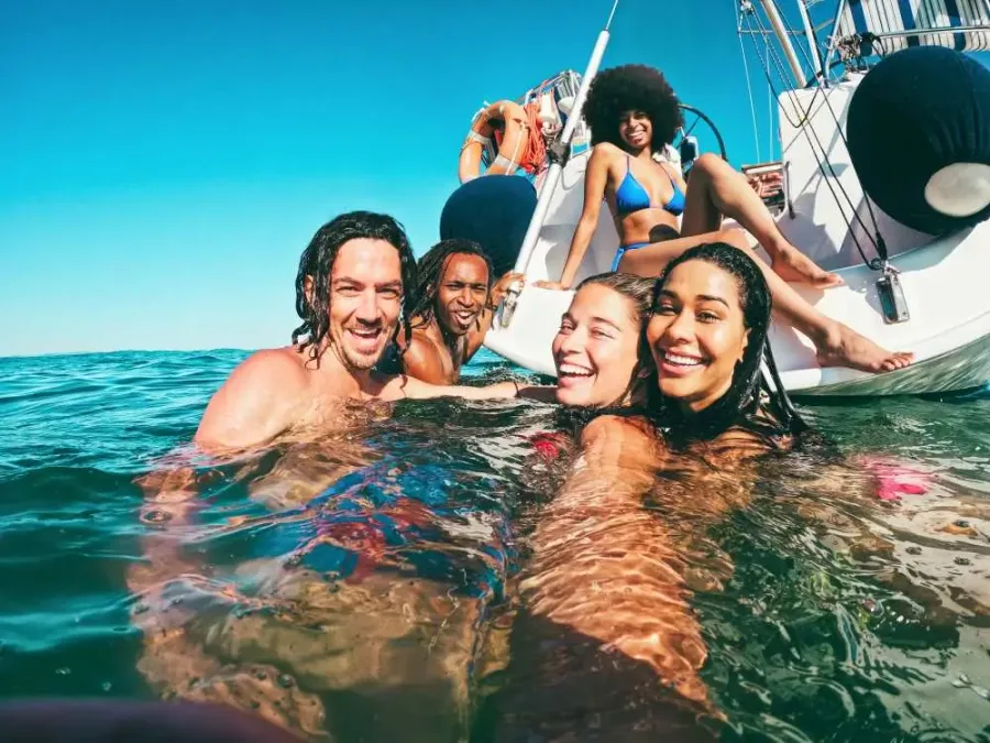 Friends enjoying a swim beside a boat